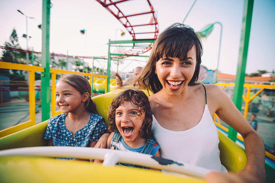Little son and daughter with mother on roller coaster ride Photograph by Wundervisuals