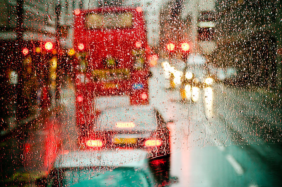London rain view to red bus through rainspecked window Photograph by Raimond Klavins