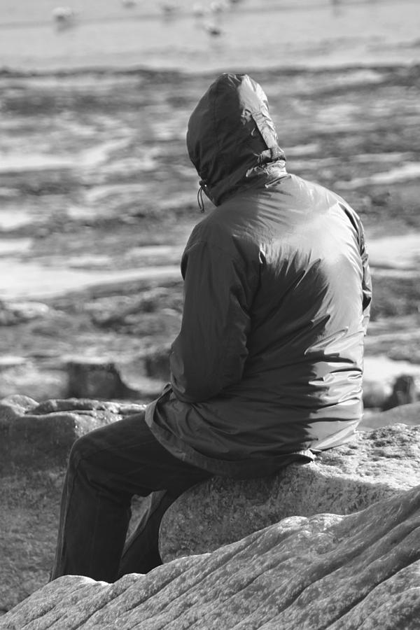 Lone Man Sitting on a Rocky Beach Photograph by Natalie Kinnear - Pixels