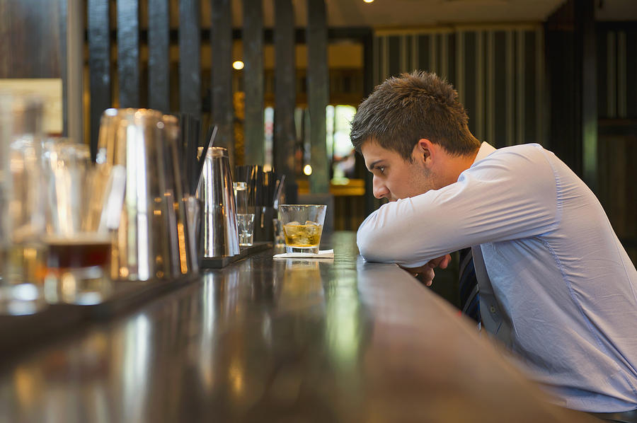 Lonely Hispanic businessman sitting at bar Photograph by Jacobs Stock Photography Ltd