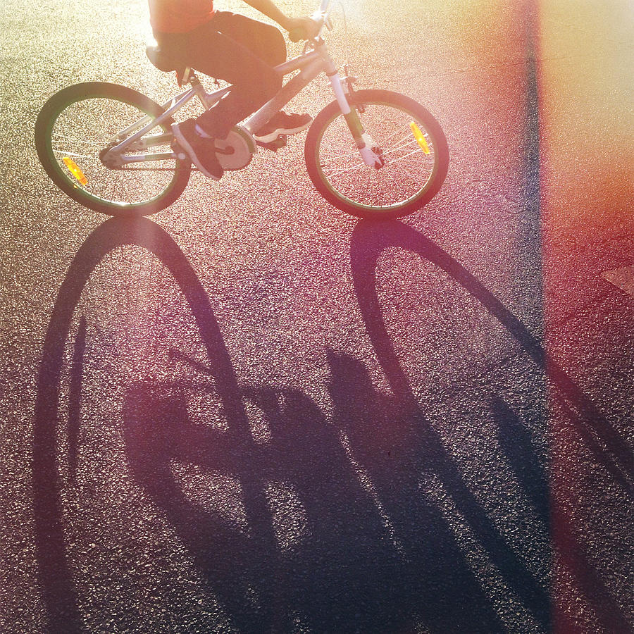 Long afternoon shadow of child riding bicycle Photograph by Jodie Griggs