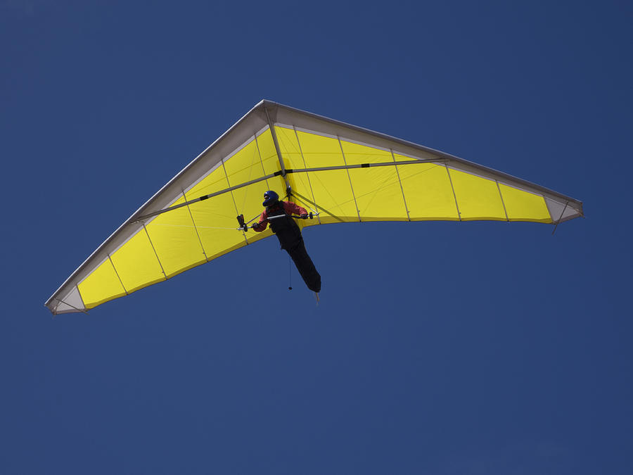 Low angle view of a person hang-gliding against clear blue sky Photograph by Tobias Titz
