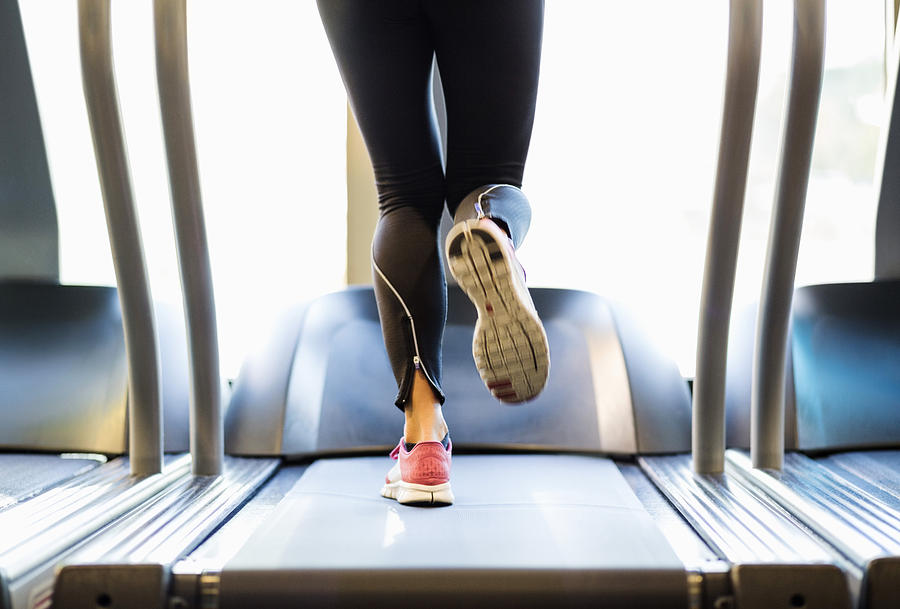Low section of woman exercising on treadmill Photograph by Maskot