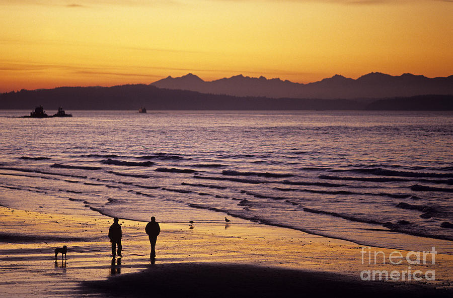 Low tide at Alki in West Seattle at sunset with silhouetted peop Photograph by Jim Corwin