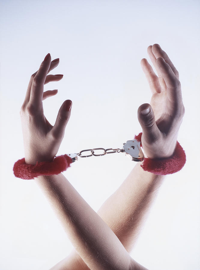 Male and female hands in red fluffy handcuffs Photograph by Peter Cade