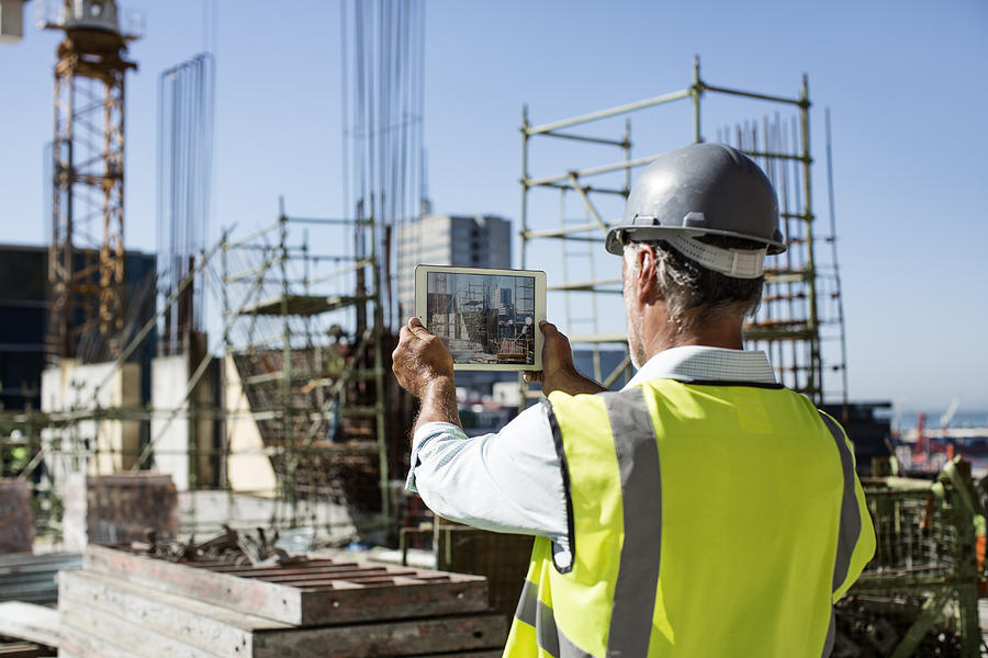 Male architect photographing construction site Photograph by Morsa Images
