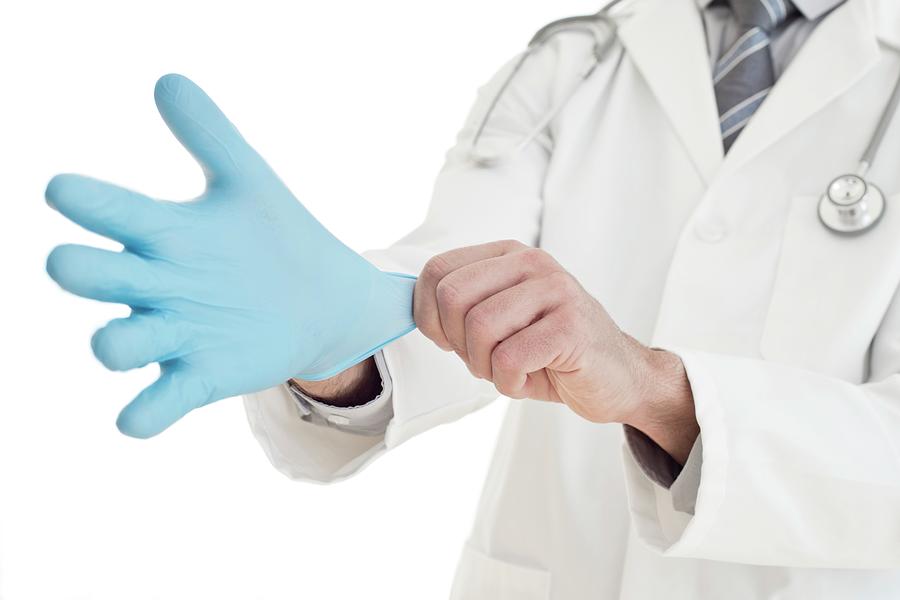 Male Doctor Putting On Blue Latex Glove 