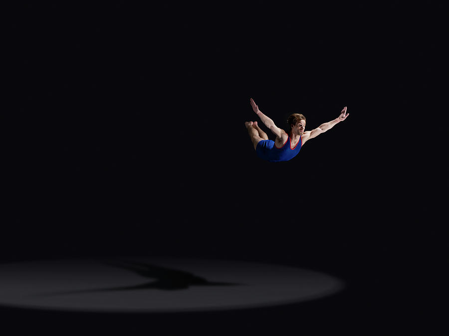 Male Gymnast Soaring Through The Air Photograph by Mike Harrington