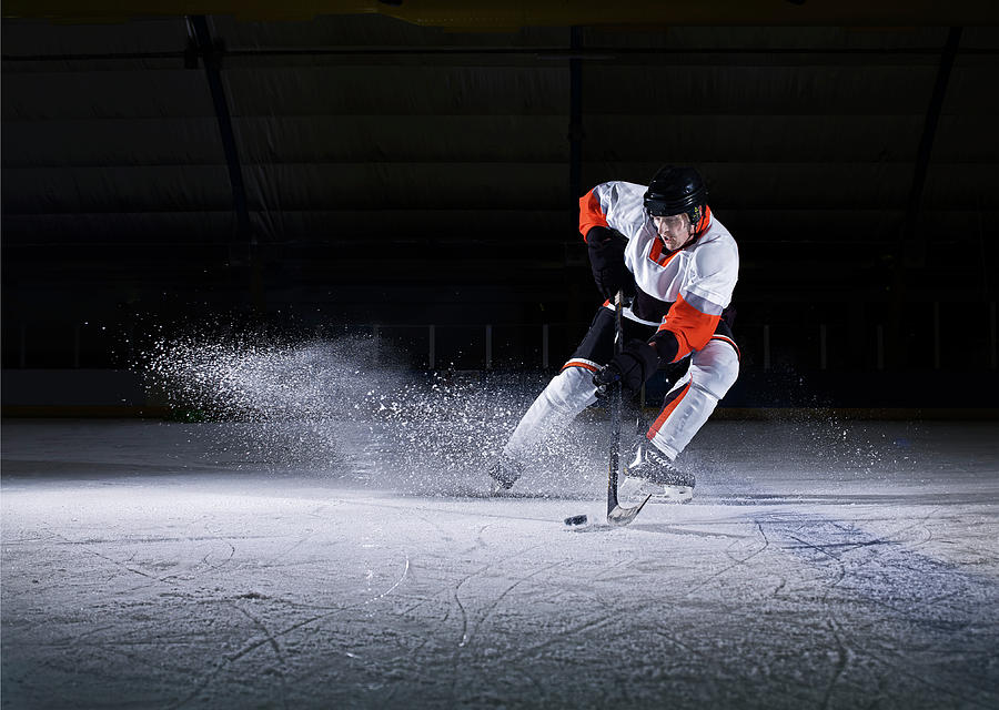 Male Ice Hockey Player Skating With Puck by Mike Harrington