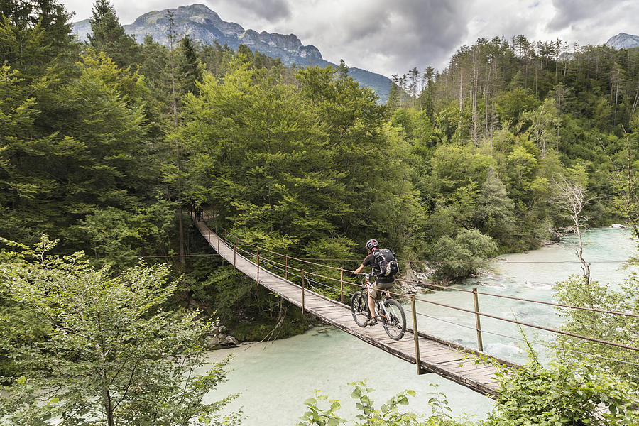Male mountainbiker is crossing a suspension bridge in Slovenia. Photograph by Saro17