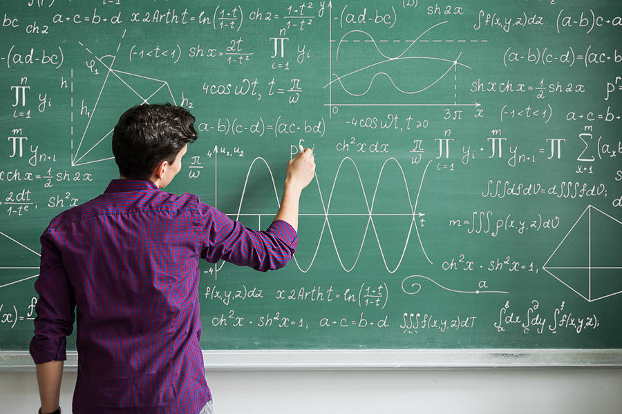 Male student writing on blackboard Photograph by Emilija Manevska