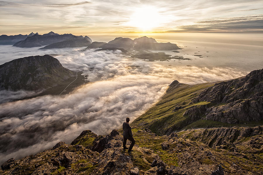 Man above the clouds on mountain Lofoten Norway Photograph by Steffen Schnur