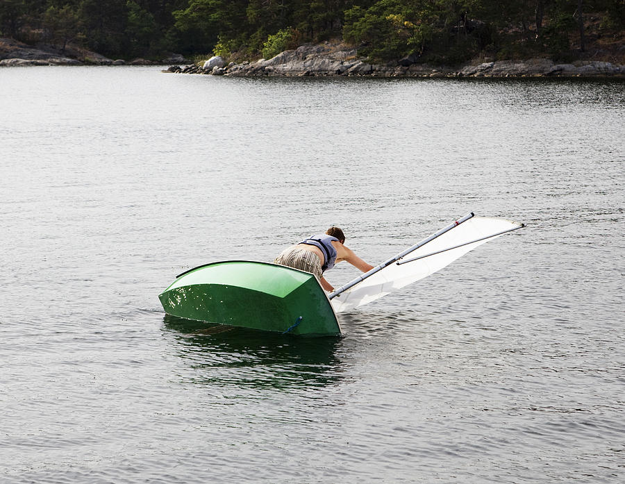 Man and dinghy falling into water Photograph by Johner Images - Walstrom, Susanne
