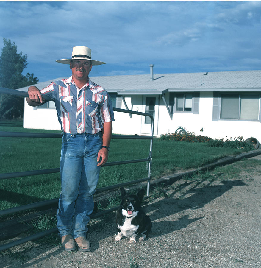 Man and dog in front of house, smiling, portrait Photograph by Kim Steele