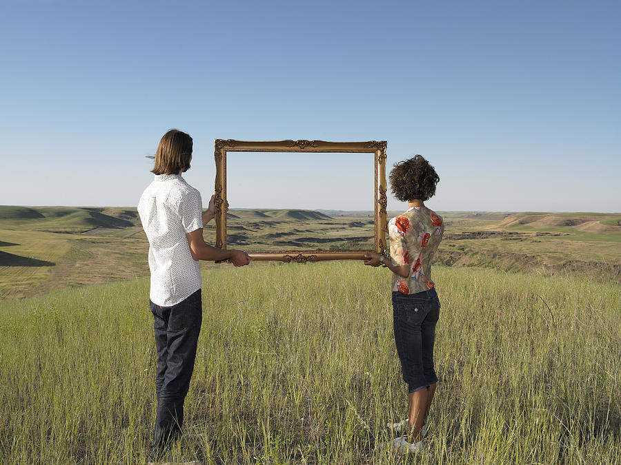 Man And Woman Holding Frame In Open Land Photograph by Andy Reynolds