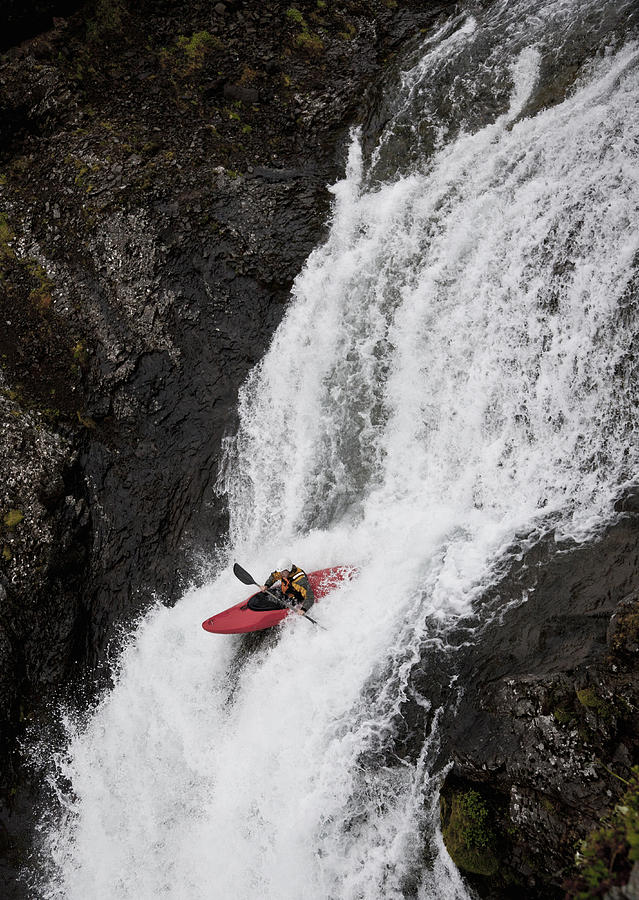 Man canoeing over rocky waterfall Photograph by Elli Thor Magnusson