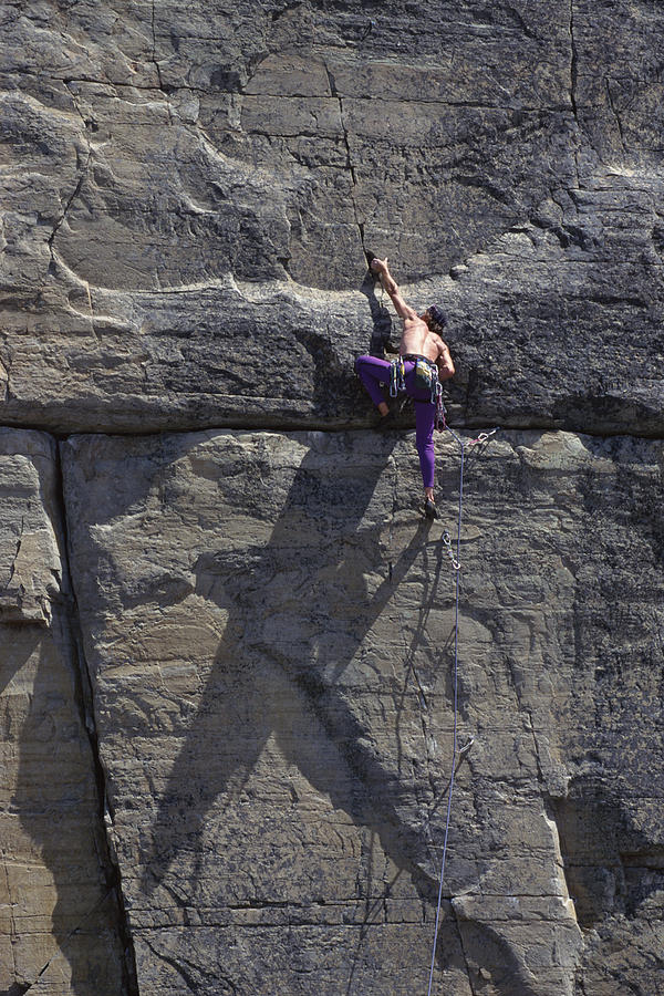 Man climbing rock wall Photograph by Comstock