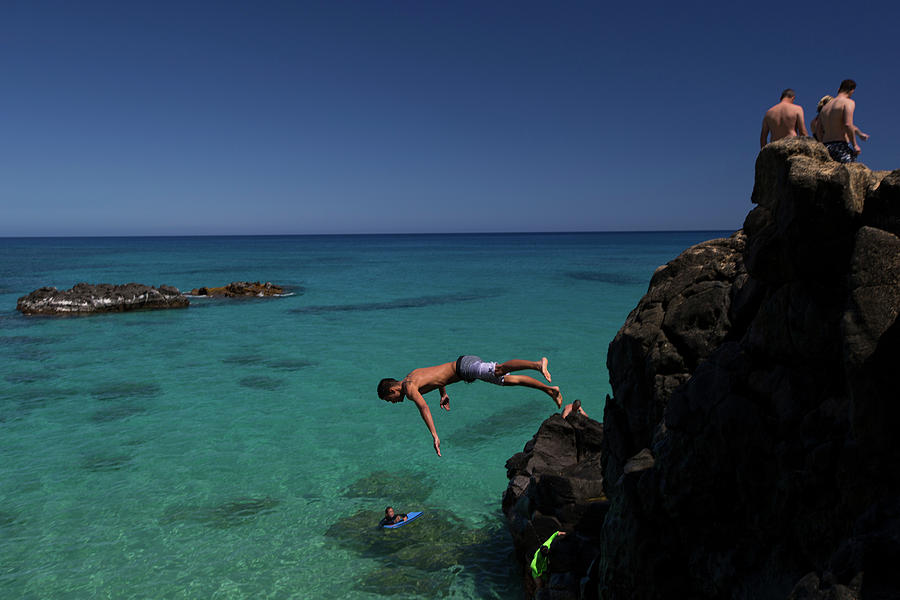 Man Diving From Rocks Into The Ocean Photograph by Panoramic Images