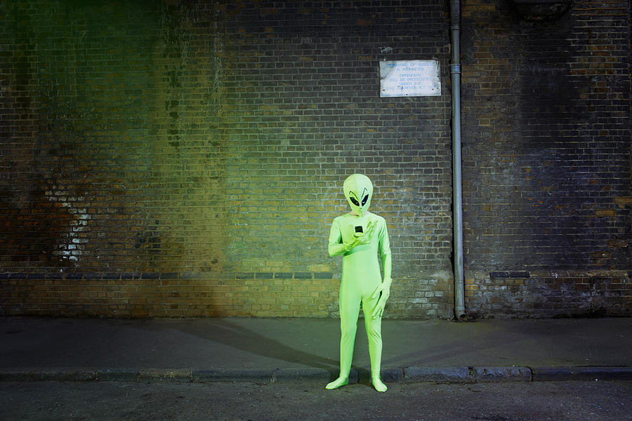 Man Dressed In Alien Costume Looking At Mobile Photograph by Tara Moore