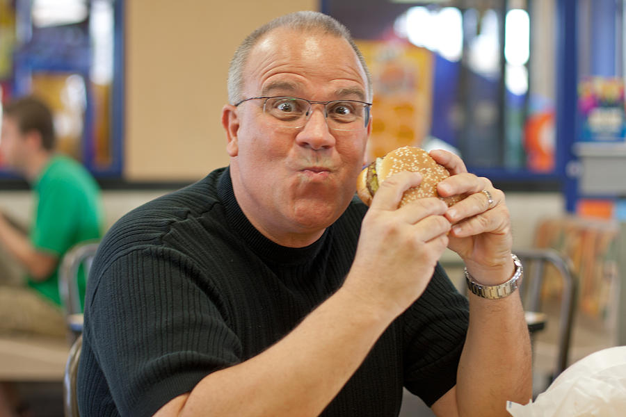 Man Eating Burger In Fast Food Restaurant Photograph By Gunter Nezhoda Pixels