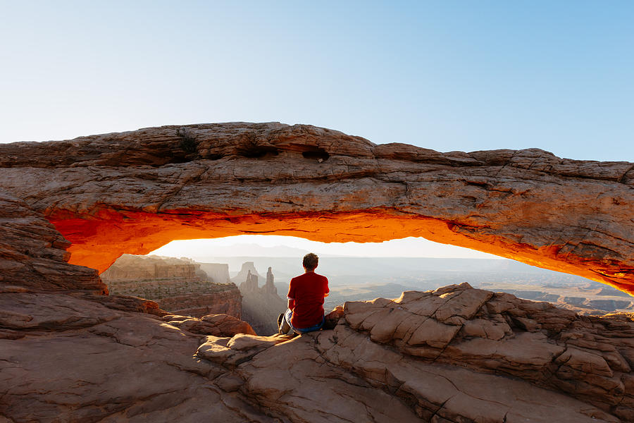 Man enjoying sunrise at Mesa arch, Canyonlands Photograph by Matteo Colombo
