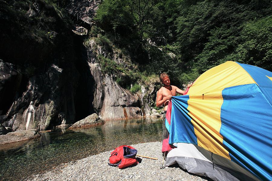 Man Erecting A Tent By A River Photograph by Mauro Fermariello/science Photo Library