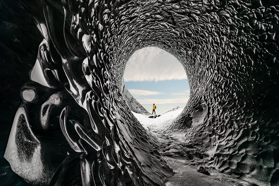Man exploring an amazing glacial cave in Iceland Photograph by Anton Petrus