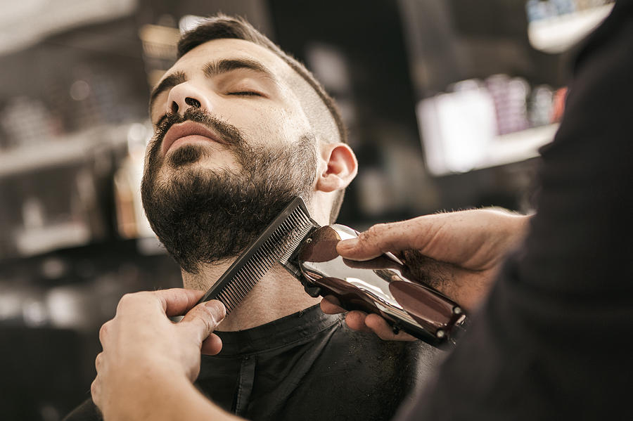 Man getting his beard trimmed with electric razor Photograph by Nastasic