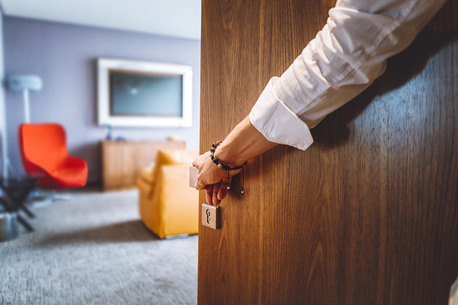 Man hand opening the door of the luxurious hotel room Photograph by Spyderskidoo