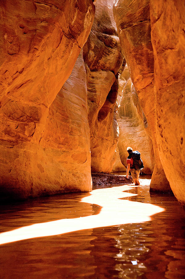 Desert Photograph - Man Hiking Through A Desert Slot Canyon by Adam Clark