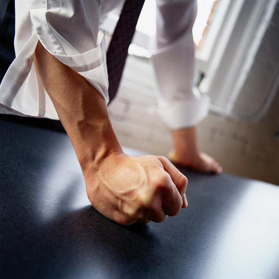 Man hitting table with fist, close-up Photograph by Digital Vision