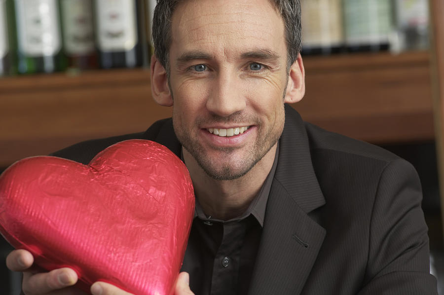 Man holding a chocolate heart Photograph by Stock4b-rf