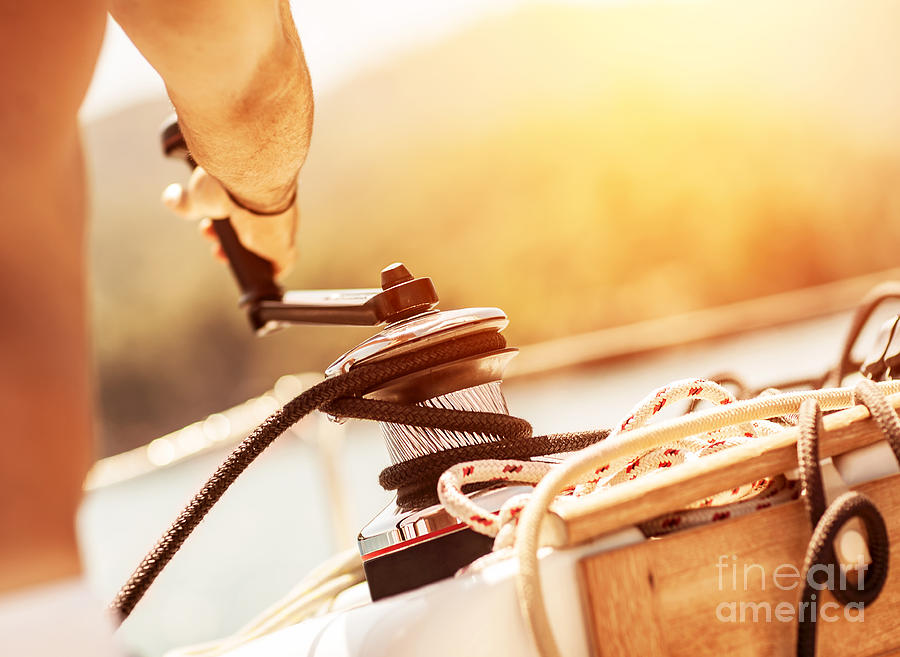 Sunset Photograph - Man holding crank on the yacht by Anna Om