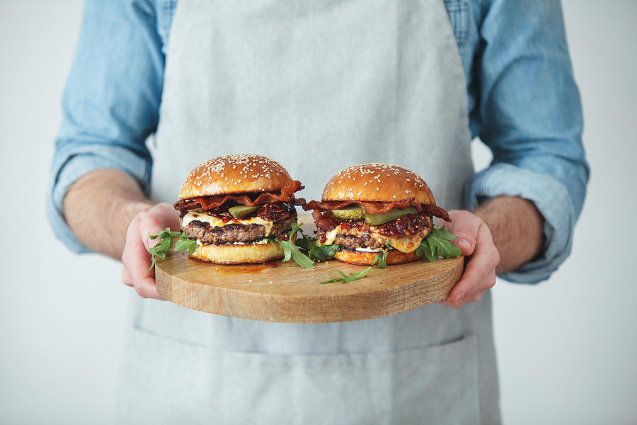 Man holding homemade angus beef burgers with bacon whisky jam Photograph by Eugene Mymrin