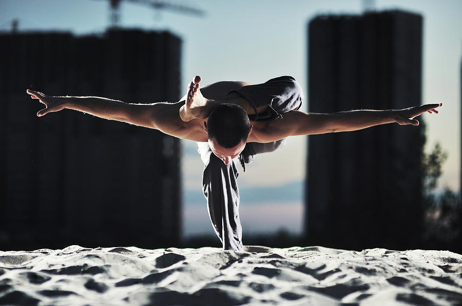 Man Holding Yoga Pose In The Sand Photograph by Myshkovsky