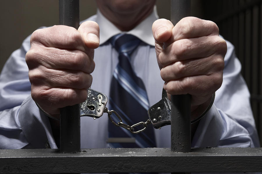 Man in handcuffs, holding prison bars, mid section, close-up of hands Photograph by Darrin Klimek
