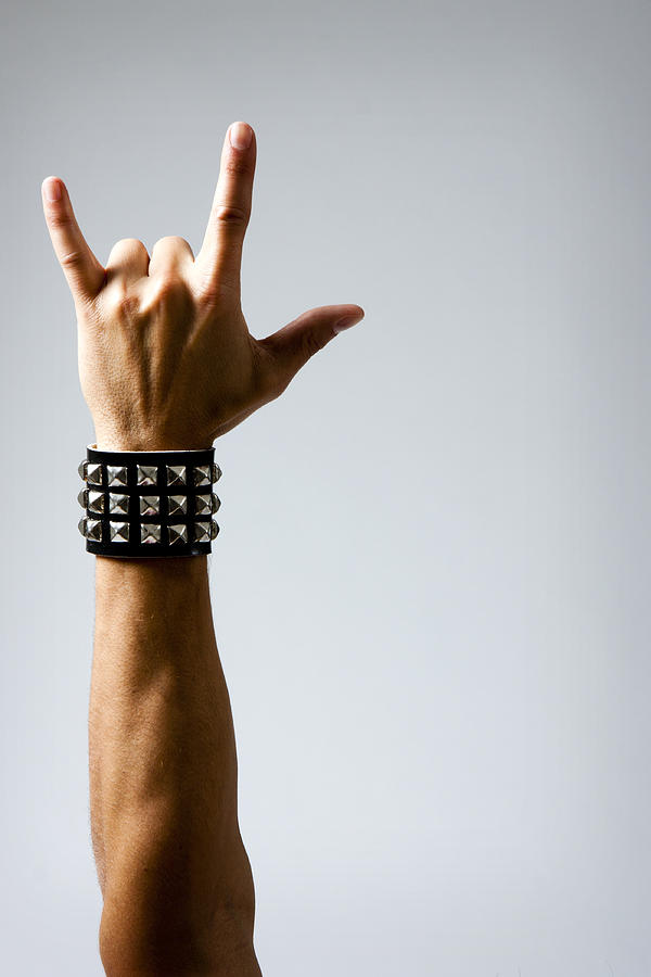 Man in Wristband making Rock & Roll Hand Symbol Photograph by Becon