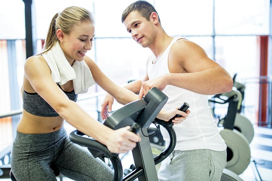 Man Instructing Woman In Gym Photograph by Science Photo Library
