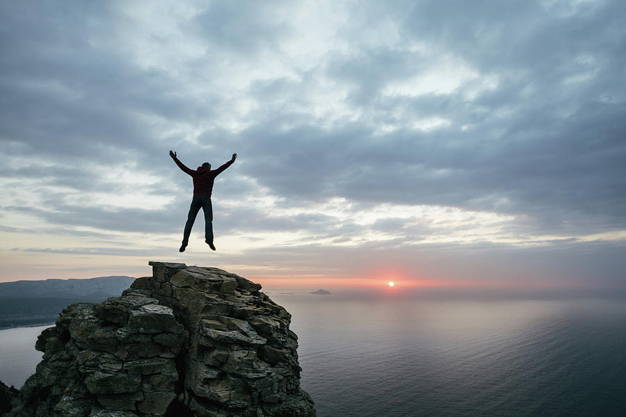 Man Jump On Top Of The Cliff Photograph by Deimagine