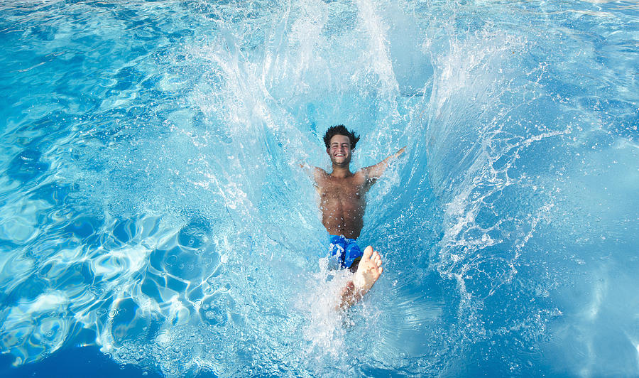 Man jumping into swimming pool Photograph by Ghislain & Marie David de Lossy