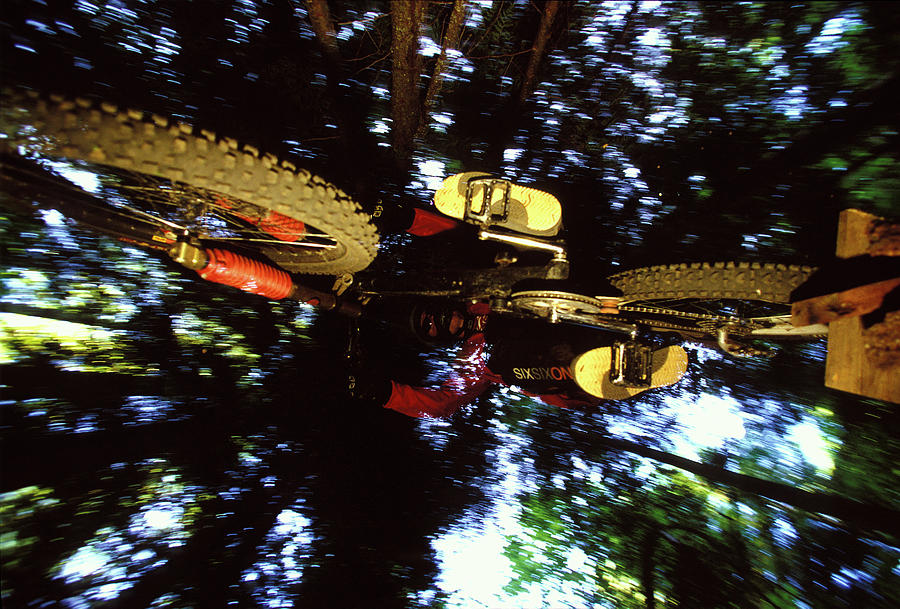 Alberta Photograph - Man Jumping Mountain Bike In The Forest by Mark S. Cosslett