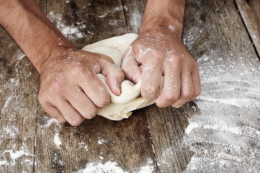 Man kneading bread dough Photograph by Howard George