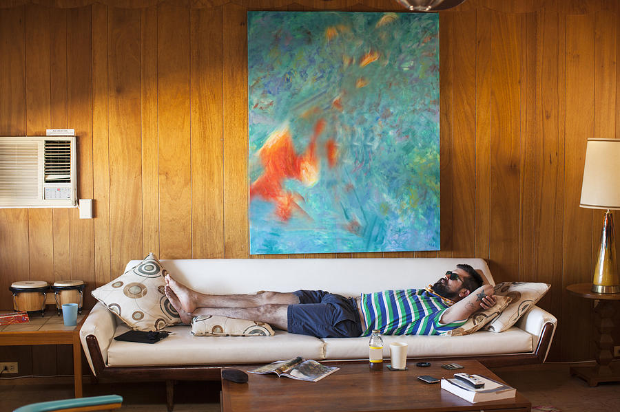 Man laying on sofa Photograph by Stephen Zeigler