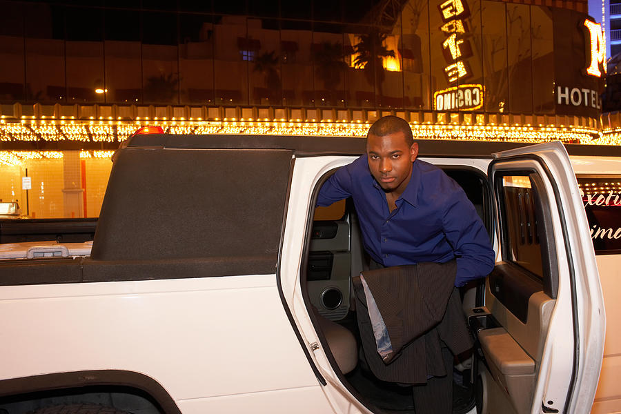 Man leaving limousine in front of casino, portrait Photograph by Erik Snyder