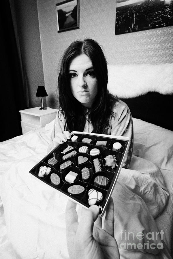 Man Offering Chocolates To Early Twenties Angry Woman In Bed In A