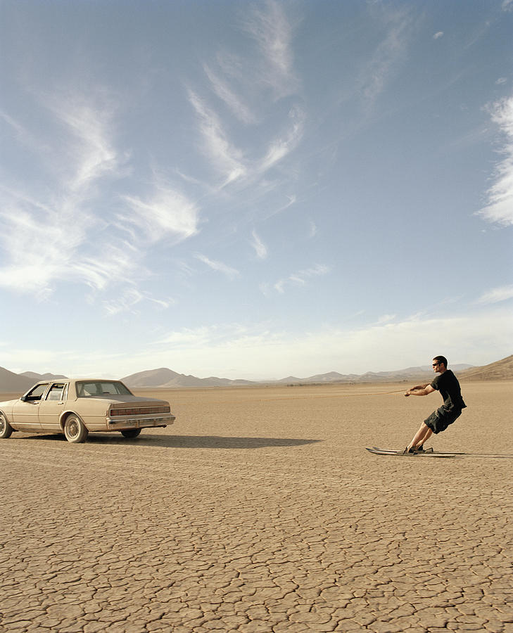 Man on water skis being pulled by car in desert, side view Photograph by Matthias Clamer
