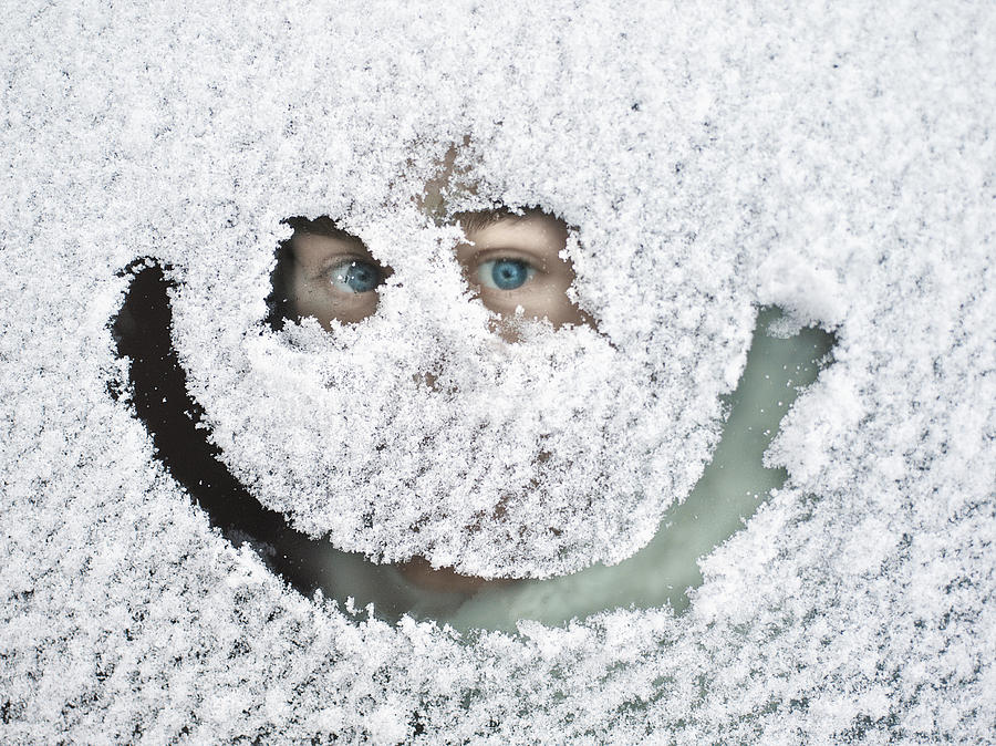 Man peeking through snow covered window Photograph by David Trood