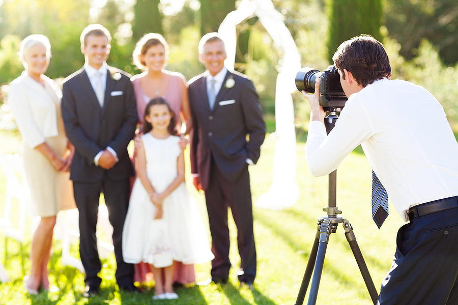 Man Photographing Family At Outdoor Wedding Photograph by Neustockimages