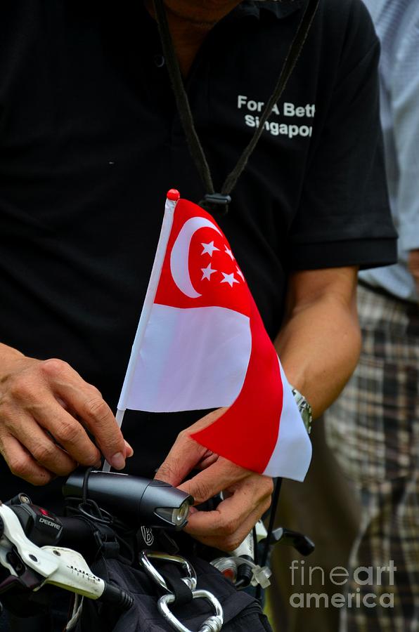 Man Plants Singapore Flag On Bicycle Photograph