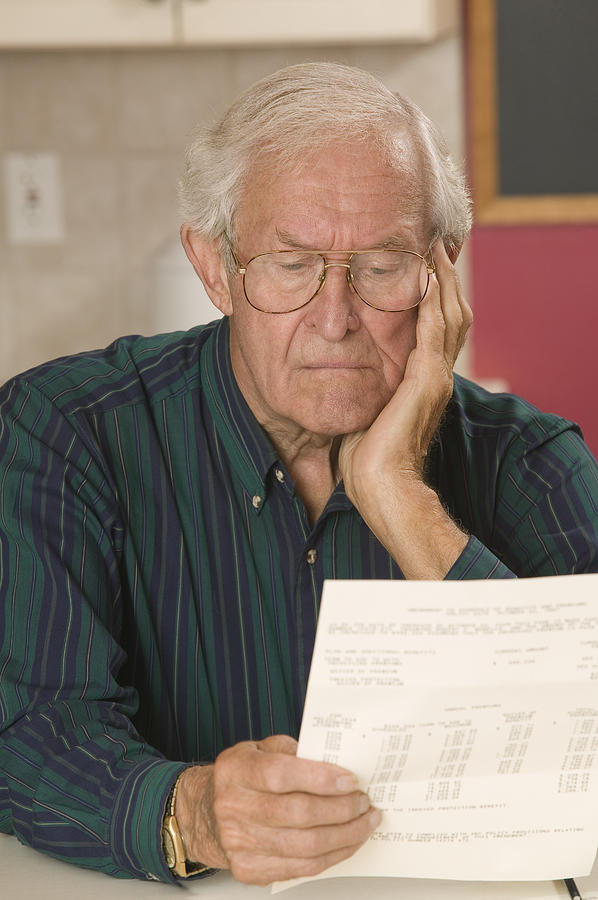 Man reading paperwork Photograph by Comstock Images